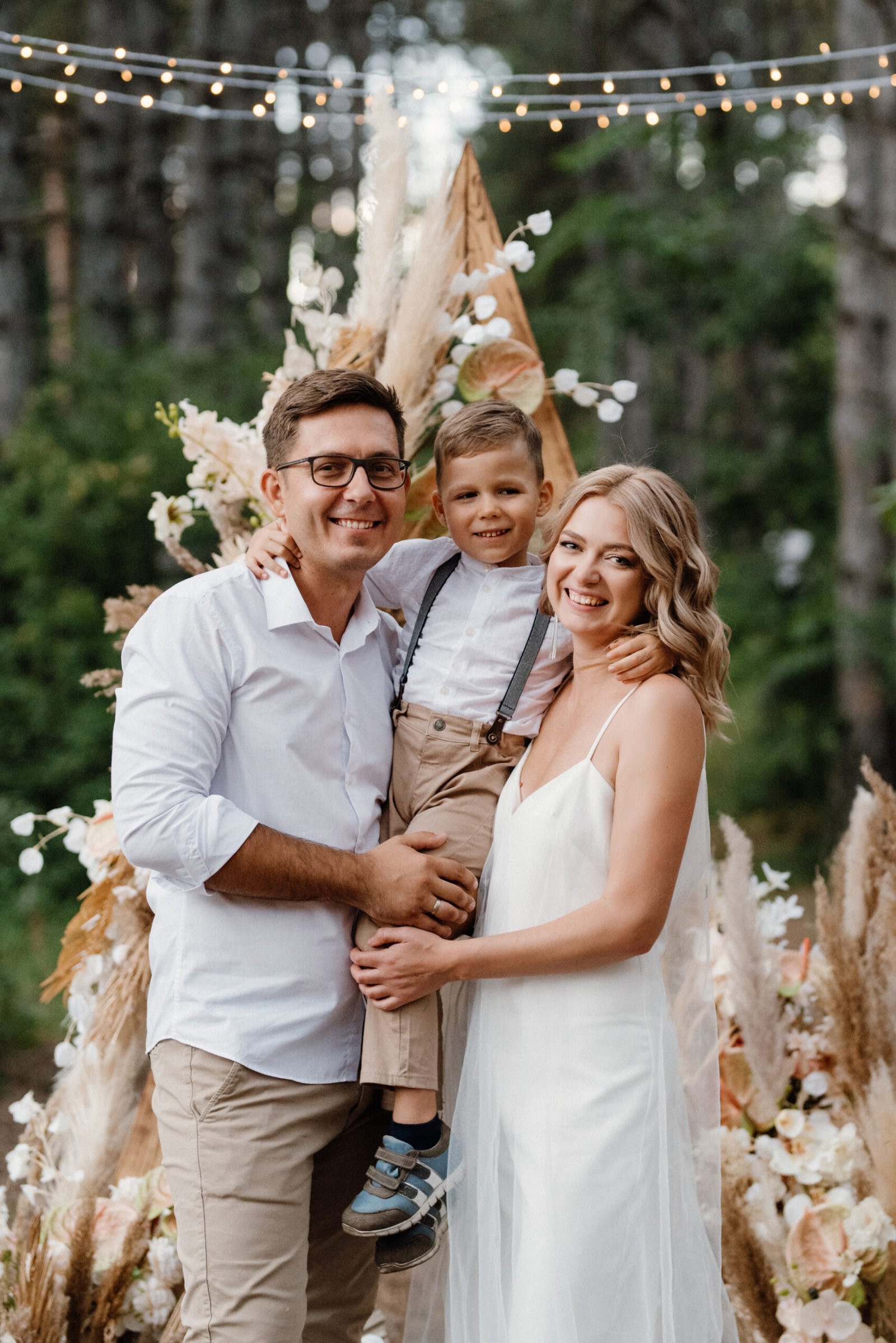 wedding ceremony of the marriage of a guy and a girl against the backdrop of an arch on a forest path
